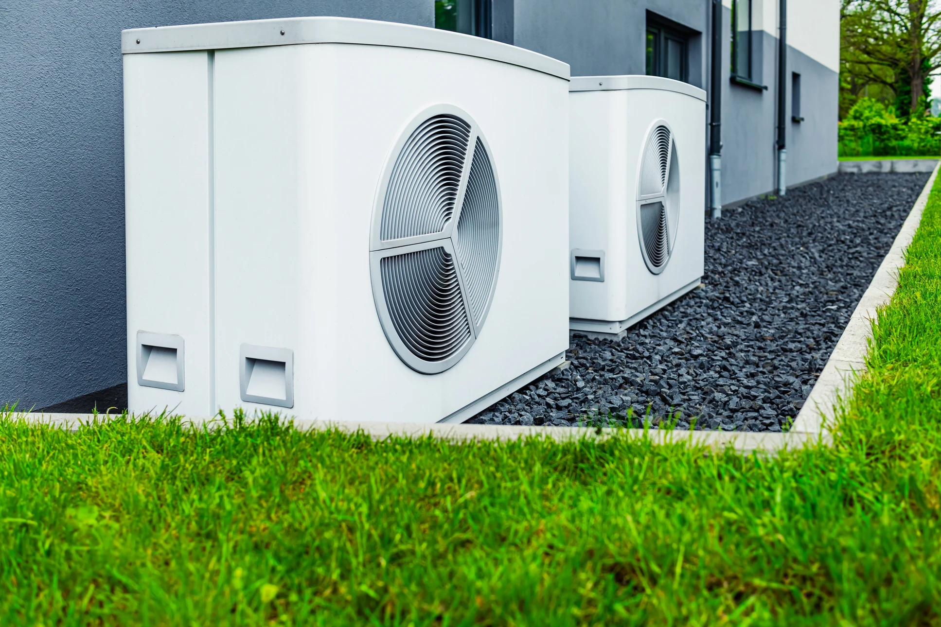 Intérieur résidentiel avec personne tenant télécommande d'air conditionné dirigée vers unité murale blanche